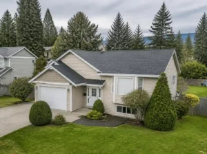 Beige suburban family home with a landscaped lawn in Burnaby